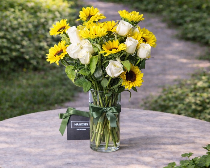 Sunflowers and white roses flower arrangement in vase 