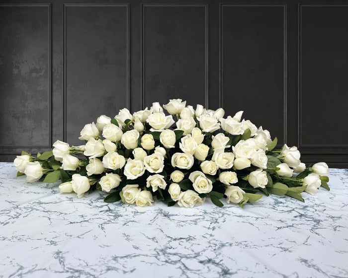 funeral spray of white roses, funeral flowers and casket flowers in white