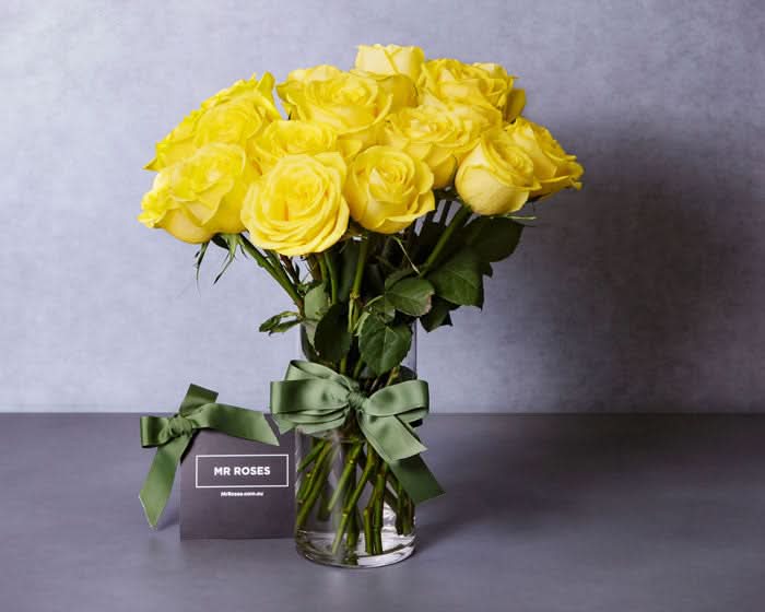 medium stemmed yellow roses in a vase