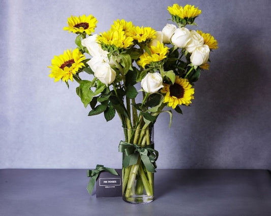 Sunflowers and white roses flower arrangement in vase
